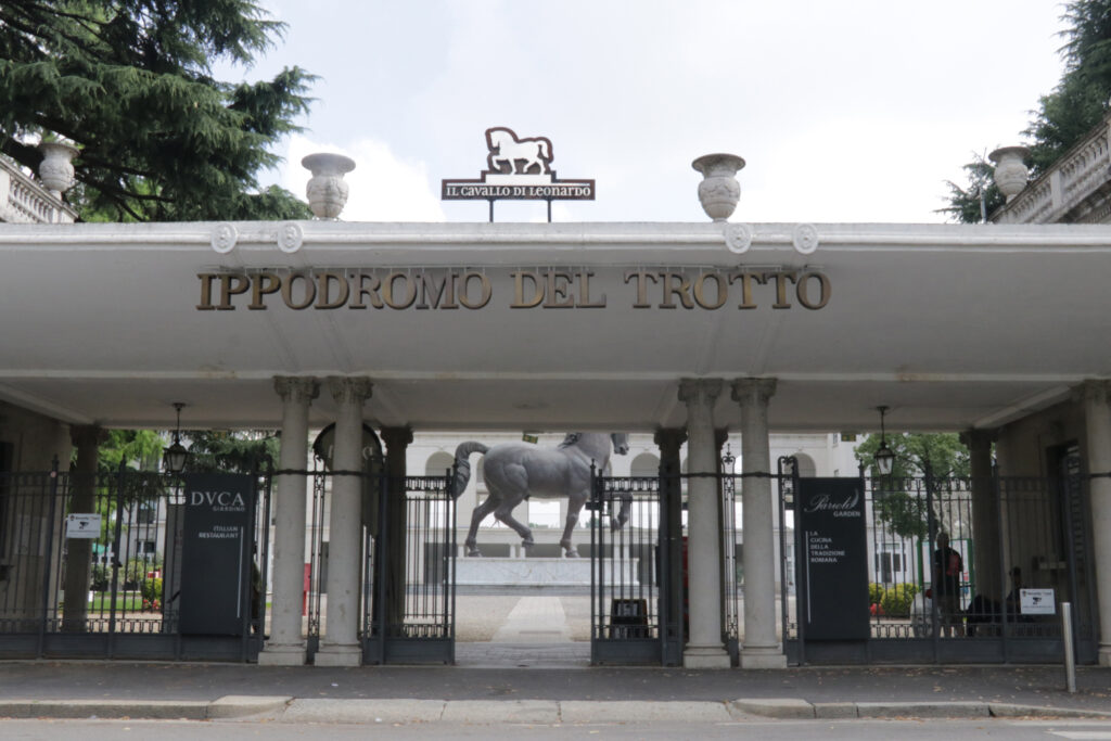 Entrance to Ippodromo Del Trotto featuring a horse-logo sign above stone columns and gates