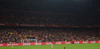 Scommesse Liga: su Betflag vittoria del Barcellona in casa del Getafe a 1.63 Full stadium filled with spectators watching a soccer match, red banners along the stands and Coca‑Cola ads around the pitch.