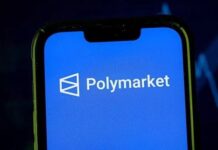 Polymarket, arrestato soldato USA: aveva guadagnato 400.000 dollari scommettendo su Maduro Smartphone screen showing the Polymarket logo on a blue background (app splash).