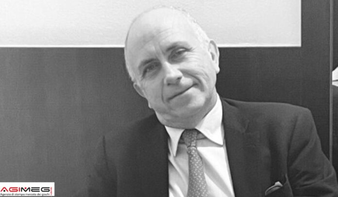 Ranieri Razzante Black-and-white portrait of a smiling older man in a suit and tie, seated indoors.