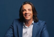 Eman Pulis a Forbes: grazie a Sigma, Roma può diventare il centro della nuova iGaming economy italiana Portrait of a man in a blue suit smiling against a dark blue backdrop, studio portrait.