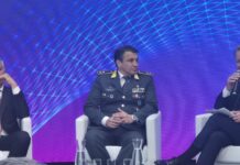 Gioco illegale, Esposito (Gen. Guardia di Finanza): “Criminalità interessata al settore, molto più difficile intervenire sull’online” Panel of men seated on stage; central figure in military uniform with medals, speaking into a mic against a blue geometric backdrop