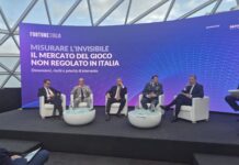 Gioco illegale, Rosato (Azione): “La politica impari distinzione tra gioco legale e illegale, necessaria un’unica regola nazionale del settore” Panel discussion on a purple stage with the Fortune Italia banner and Italian text, five men in suits seated in white chairs