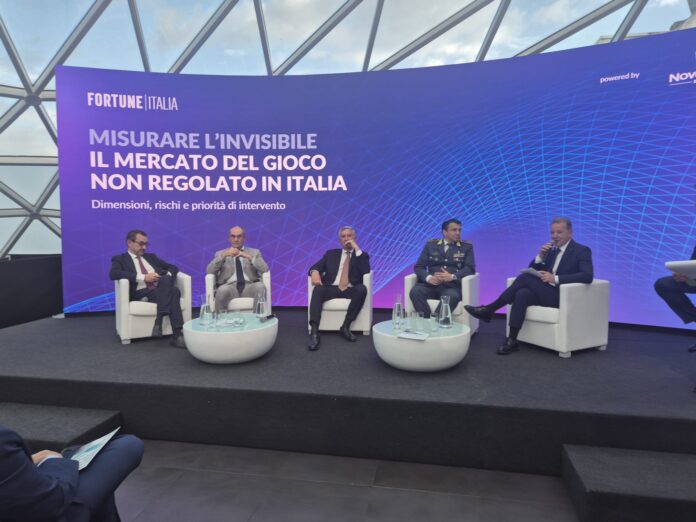 Rosato gioco illegale Panel discussion on a purple stage with the Fortune Italia banner and Italian text, five men in suits seated in white chairs