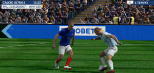 Mondiali Virtual Eurobet | AGIMEG Soccer players duel for the ball on a green field, one in a blue kit with red socks and the other in light blue–white stripes, with a cheering crowd in the stands behind them